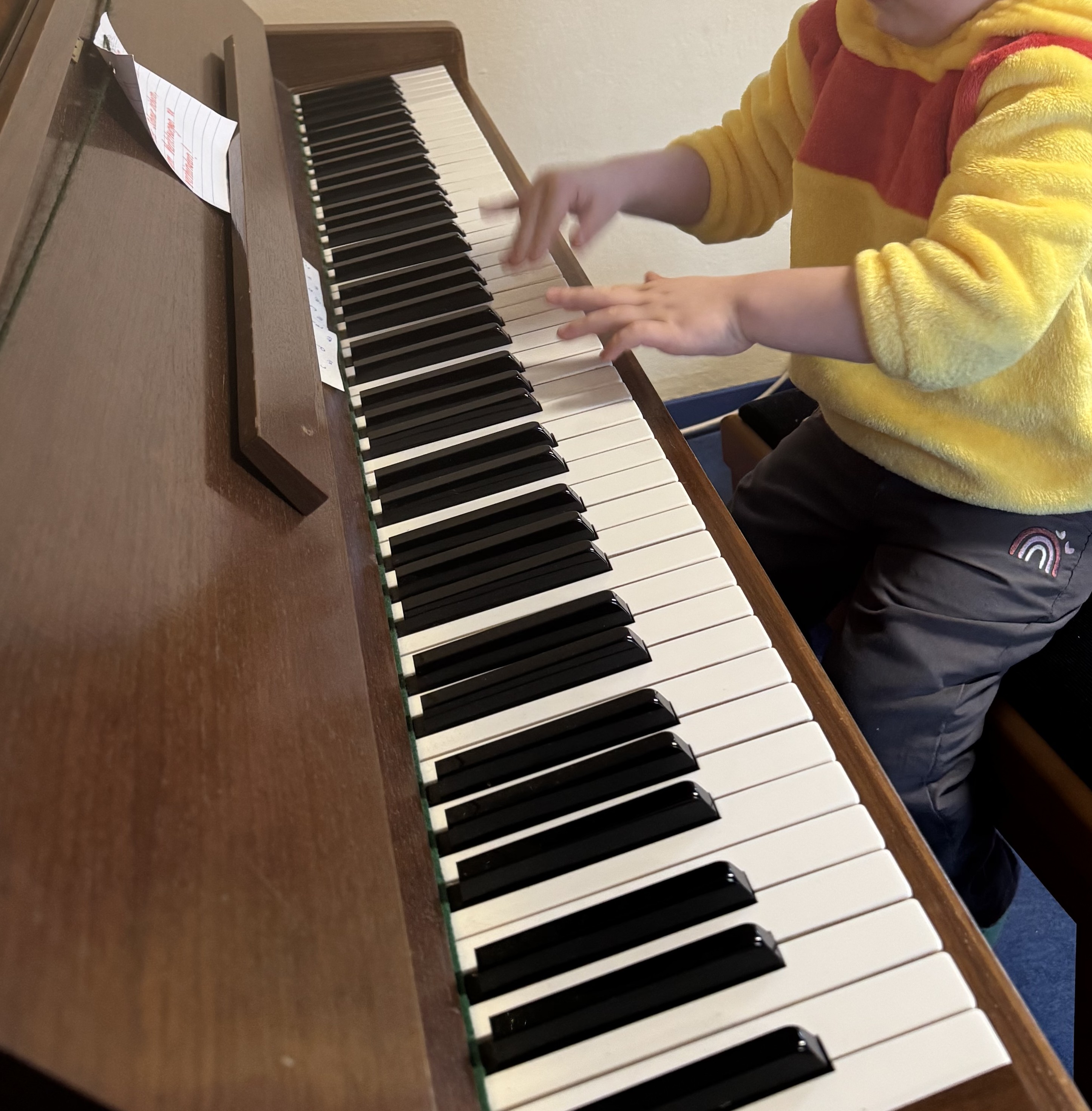 Kind macht Musik am Klavier in der Penthaus Kita