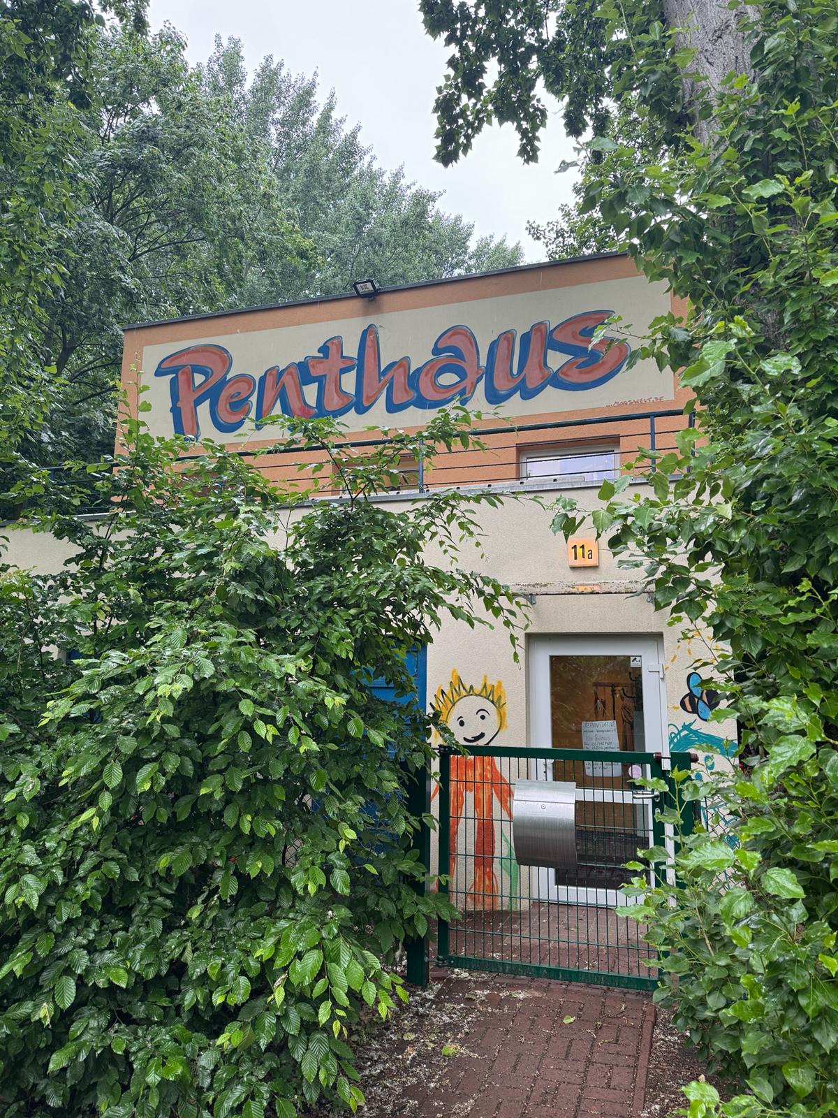 Eingang der Penthaus Kita in Berlin-Reinickendorf, umgeben von Gr&uuml;n