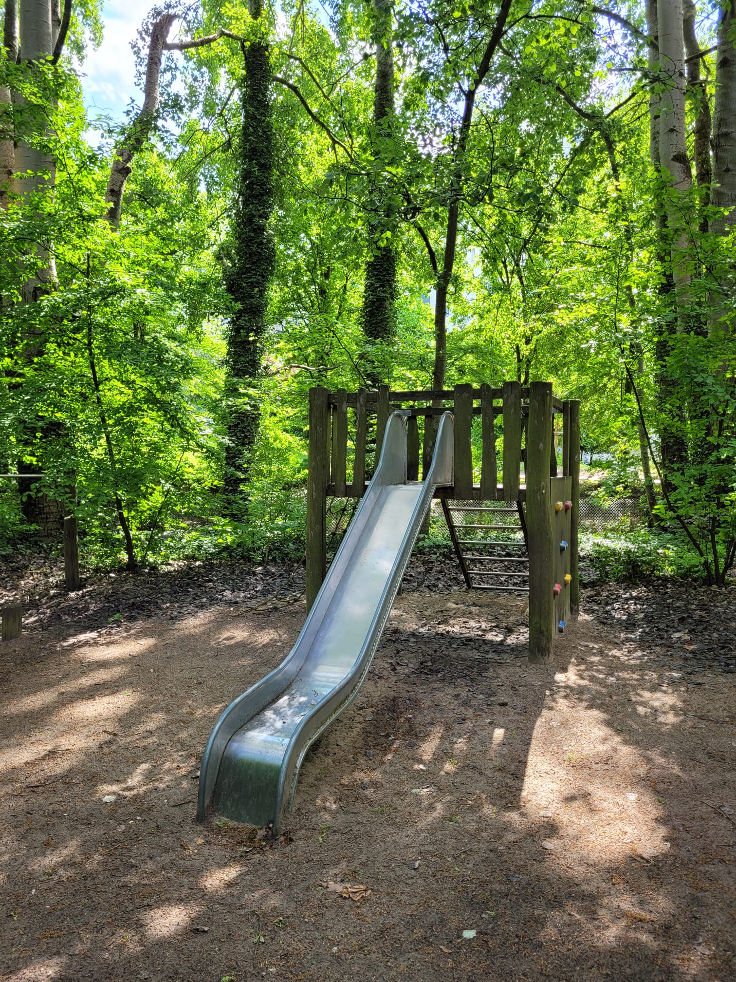 Metallrutsche mit Kletterturm im naturnahen Garten der Penthaus Kita