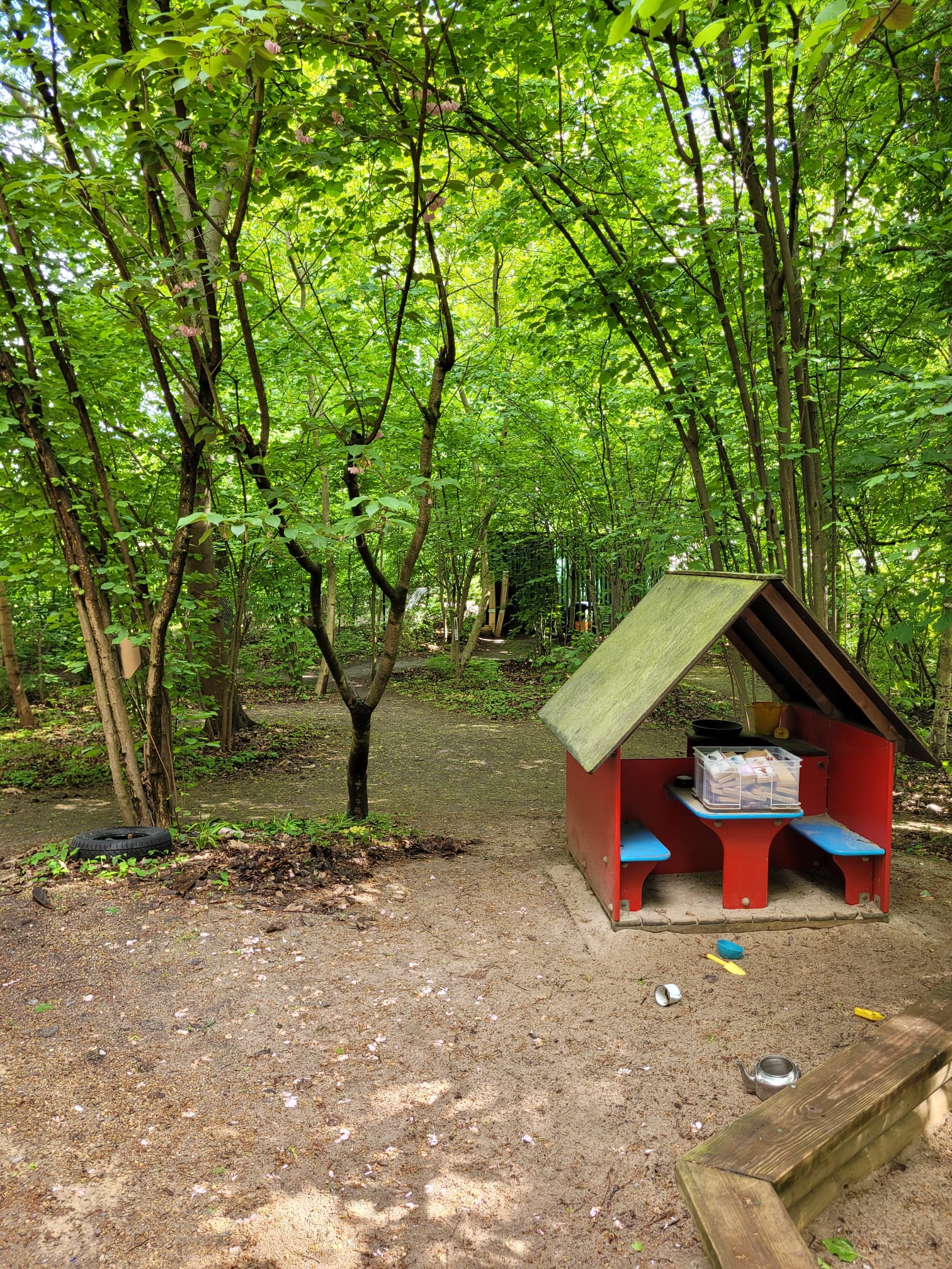 Rotes Spielhaus mit Bänken im Garten