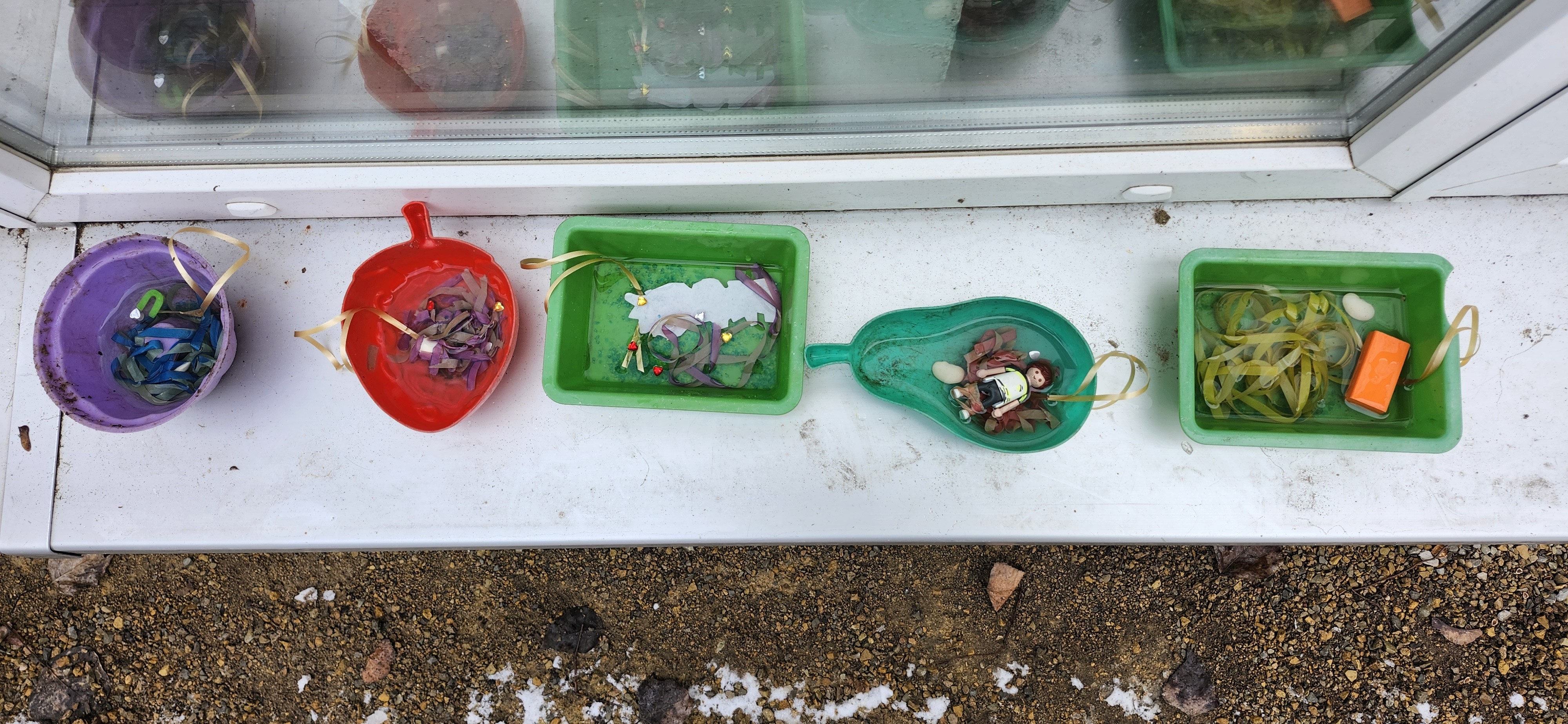 Bunte Schalen mit B&auml;ndern und Figuren gefrieren drau&szlig;en